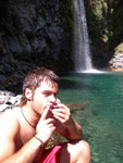 Photo de Christopher jouant de l'armonica sous une cascade en Amérique du Sud