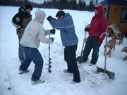 Photo du groupe creusant un trou dans la glace en Laponie